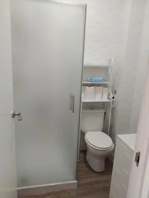 a white bathroom with a toilet and a sink at Apartamento Dali in El Puerto de Santa María