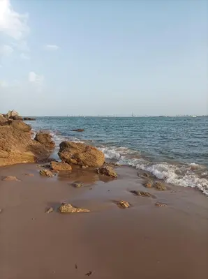 a sandy beach with rocks and the ocean at Apartamento Dali in El Puerto de Santa María