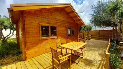 a wooden cabin with a table and chairs on a deck at Cosy Cabin in Cádiz in Chiclana de la Frontera