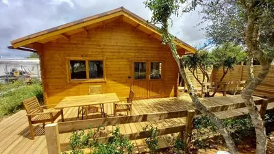 a log cabin with a table and chairs on a deck at Cosy Cabin in Cádiz in Chiclana de la Frontera