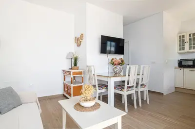 a living room with a table and a dining room at Casa Sol in Conil de la Frontera