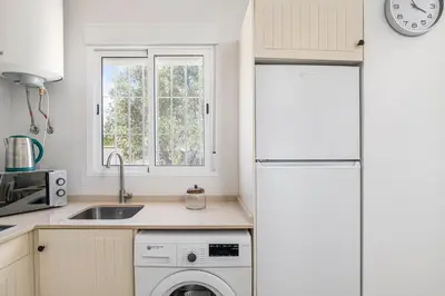a kitchen with a white refrigerator and a dishwasher at Casa Sol in Conil de la Frontera