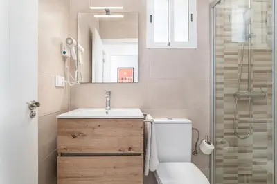 a bathroom with a sink and a toilet and a mirror at Casa Sol in Conil de la Frontera