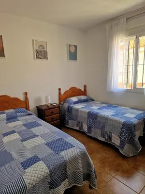 a bedroom with two beds and a window at Primera Línea de Playa Casa adosada La Balconera in Chiclana de la Frontera