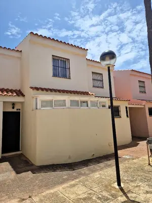 a white house with a garage and a street light at Primera Línea de Playa Casa adosada La Balconera in Chiclana de la Frontera