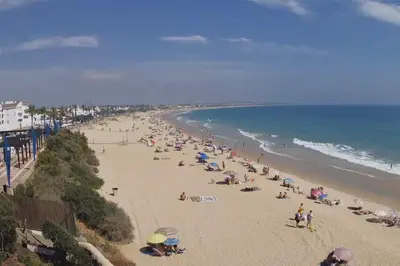 a group of people on a beach with the ocean at Primera Línea de Playa Casa adosada La Balconera in Chiclana de la Frontera