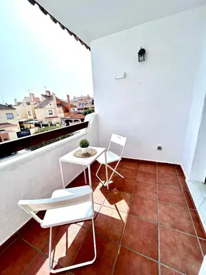 a balcony with two chairs and a table on a roof at Apartamento Empul Rota Príncipe in Rota
