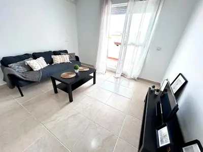 a living room with a blue couch and a table at Apartamento Empul Rota Príncipe in Rota