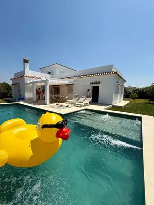 a rubber duck in a swimming pool in front of a house at Mirador las Cumbres Conil - Piscina Jardín XL in Conil de la Frontera