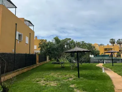 an umbrella in a yard next to a building at Villa Costa Ballena in Rota