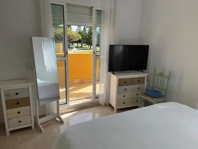 a bedroom with a bed and a tv on a dresser at Villa Costa Ballena in Rota