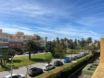 a street with cars parked in a parking lot at Villa Costa Ballena in Rota