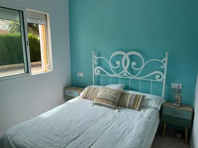 a bedroom with a bed with a blue wall at Villa Costa Ballena in Rota