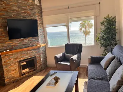 a living room with a brick fireplace and a tv at Apartamento en Fuentebravia in El Puerto de Santa María