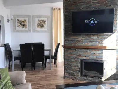a living room with a fireplace with a tv on a brick wall at Apartamento en Fuentebravia in El Puerto de Santa María
