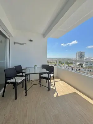 a dining room with a table and chairs and a large window at Apartamento Valdelagrana vistas al Mar in El Puerto de Santa María