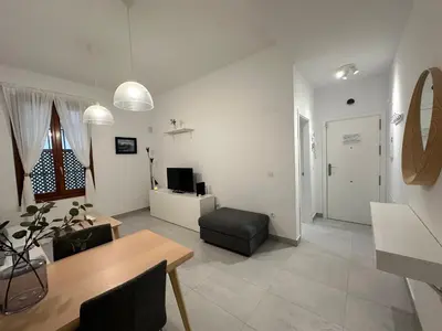 a living room with a table and a chair at La Caleta in Cádiz