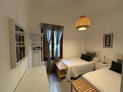 a small room with two beds and a window at La Caleta in Cádiz