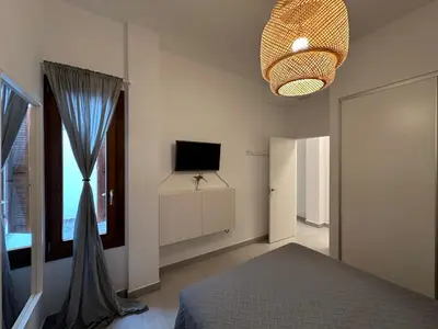 a bedroom with a bed and a tv and a window at La Caleta in Cádiz
