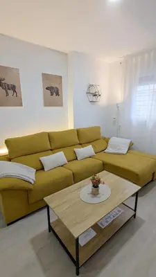 a living room with a yellow couch and a coffee table at Apartamento Victoria in San Fernando