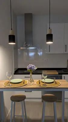 a kitchen with two tables with glasses and flowers on it at Apartamento Victoria in San Fernando