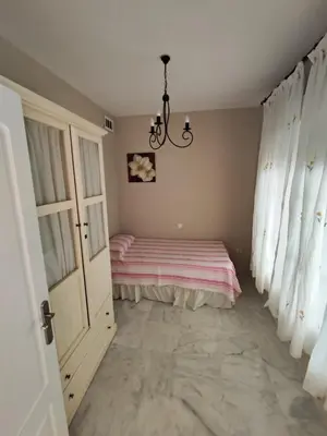 a bedroom with a bed and a chandelier at 4 dormitorios Valdelagrana in El Puerto de Santa María