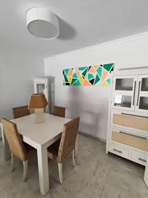 a dining room with a white table and chairs at 4 dormitorios Valdelagrana in El Puerto de Santa María