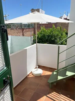 a toilet on a balcony with an umbrella at Casa Álamo en Chipiona in Chipiona