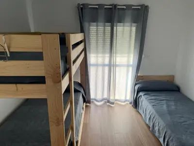 a bedroom with two bunk beds and a window at Casa Álamo en Chipiona in Chipiona