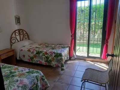 a bedroom with two beds and a window at Casa Juan José in Conil de la Frontera