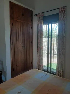 a bedroom with a bed and a large window at Casa Juan José in Conil de la Frontera