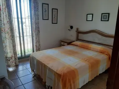 a bedroom with a bed and a large window at Casa Juan José in Conil de la Frontera