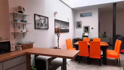 a dining room with a table and orange chairs at EL Lucernario in Jerez de la Frontera