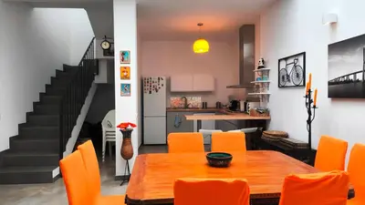 a dining room with a table and orange chairs at EL Lucernario in Jerez de la Frontera
