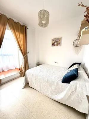 a bedroom with a white bed and a window at Alojamiento Montero in Sanlúcar de Barrameda