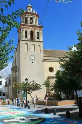 a large building with a tower with a clock on it at Alojamiento Montero in Sanlúcar de Barrameda