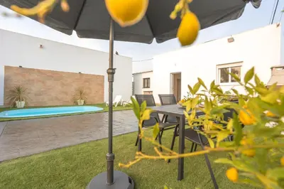 a patio with a table and chairs and an umbrella at La casita nueva in Cádiz