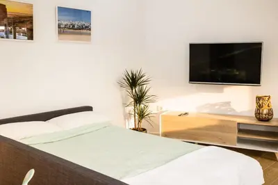 a bedroom with a bed and a flat screen tv at La casita nueva in Cádiz