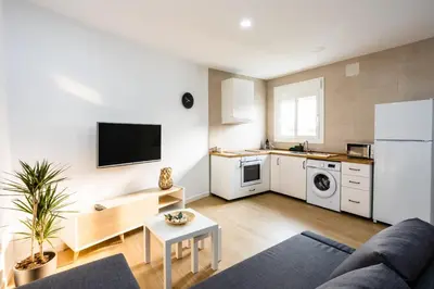 a living room with a couch and a kitchen at La casita nueva in Cádiz