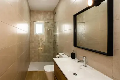 a bathroom with a sink and a toilet and a mirror at La casita nueva in Cádiz