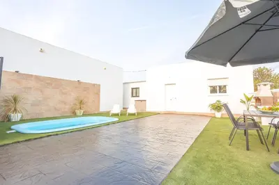 a patio with an umbrella and a swimming pool at La casita nueva in Cádiz