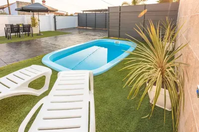 a backyard with a swimming pool and a white bench at La casita nueva in Cádiz