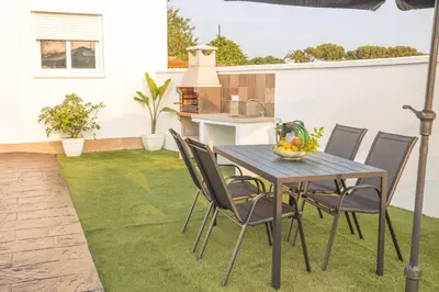 a patio with a table and chairs on the grass at La casita nueva in Cádiz