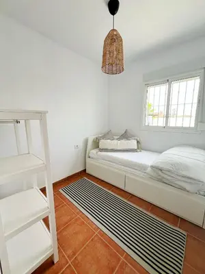 a white room with a bed and a ladder at Chalet Vacacional ELIÁ -Piscina Privada, BBQ, Wifi in Chiclana de la Frontera