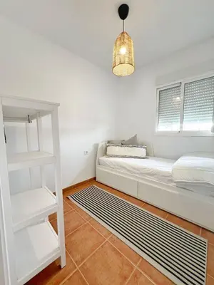 a white room with a bed and a ladder at Chalet Vacacional ELIÁ -Piscina Privada, BBQ, Wifi in Chiclana de la Frontera
