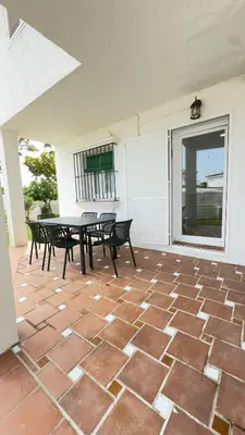 a patio with a table and chairs on it at Punto Mágico, apartamento junto al mar in Poblado de Sancti Petri