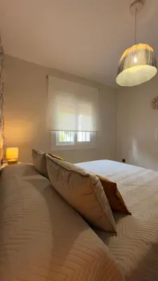 a bedroom with a bed with pillows on it at Punto Mágico, apartamento junto al mar in Poblado de Sancti Petri