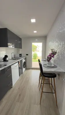 a kitchen with a table and a dining room at Punto Mágico, apartamento junto al mar in Poblado de Sancti Petri