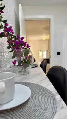 a table with a vase with purple flowers on it at Punto Mágico, apartamento junto al mar in Poblado de Sancti Petri