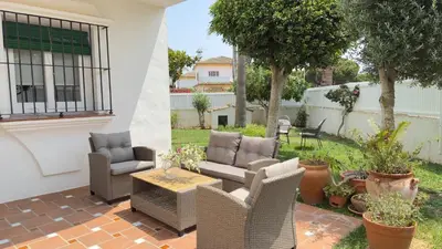 a patio with wicker chairs and a table at Punto Mágico, apartamento junto al mar in Poblado de Sancti Petri